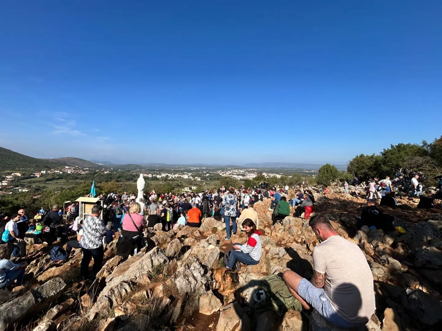 A crowd of people sitting on top of rocks.