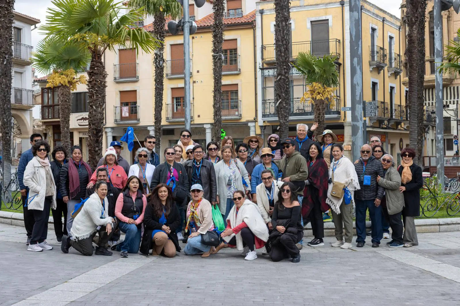A group of people posing for a picture in front of palm trees.